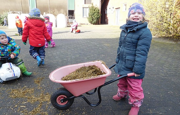 Kind mit Schiebkarre